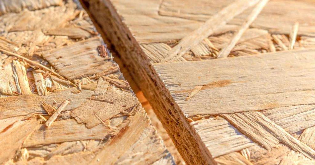 Close-up of OSB particle board showing exposed strands and seam gap
