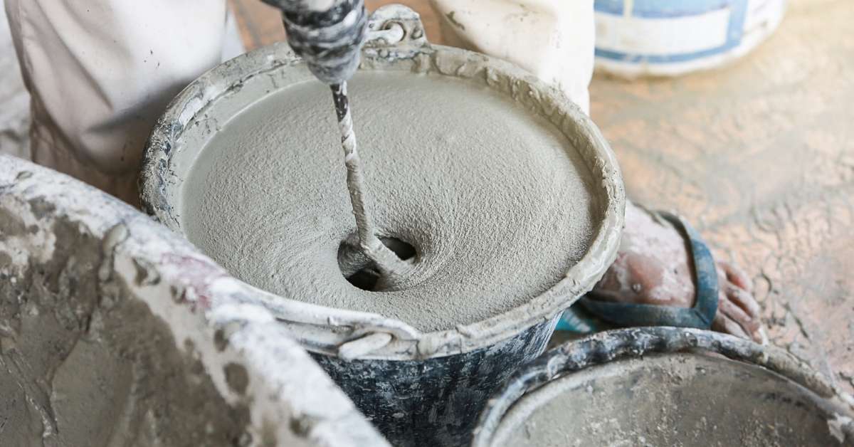 Wet cement spinning inside a rotating concrete mixer drum.