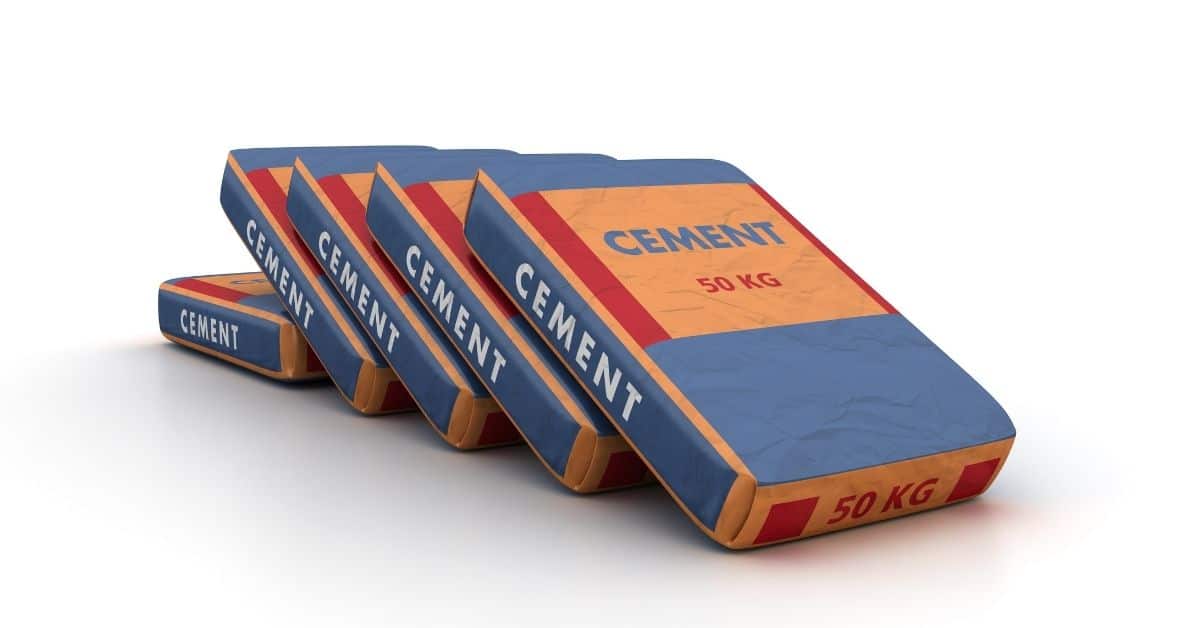Several cement bags labeled CEMENT stacked in a leaning row.