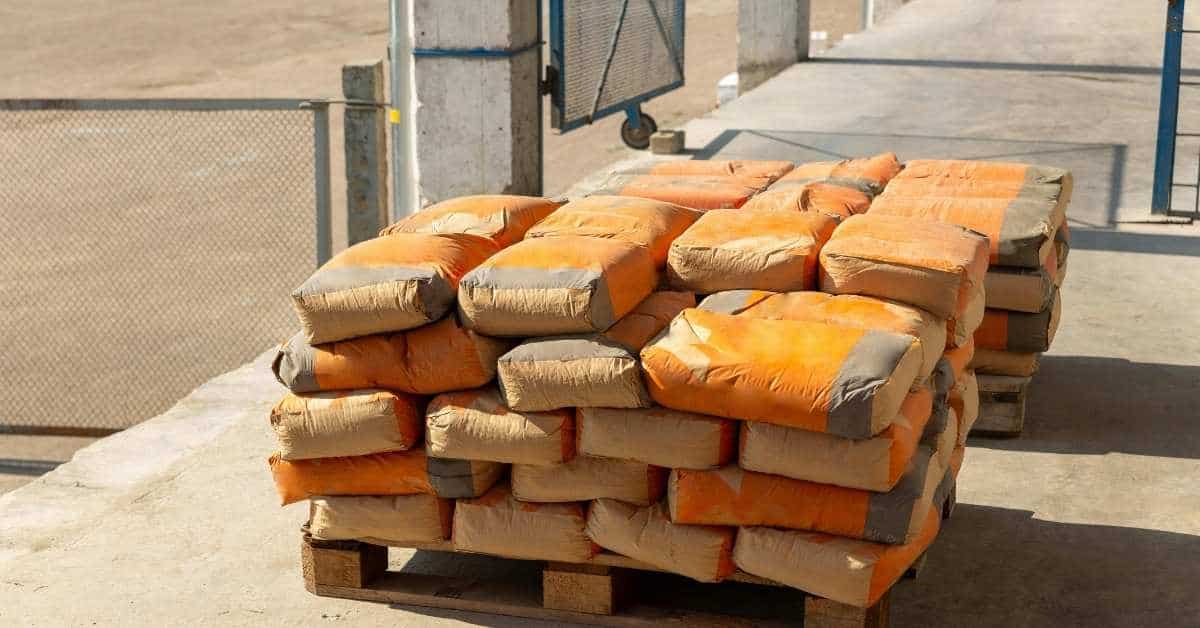 Stacked cement bags on a wooden pallet at a construction site