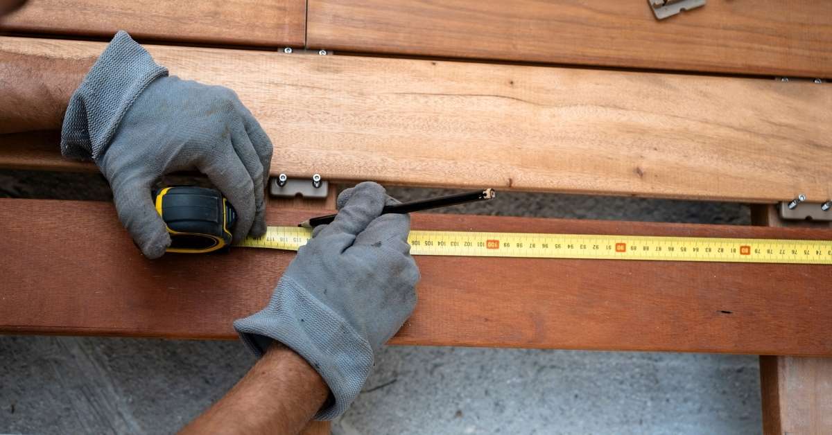 Measuring a wooden beam with a tape measure