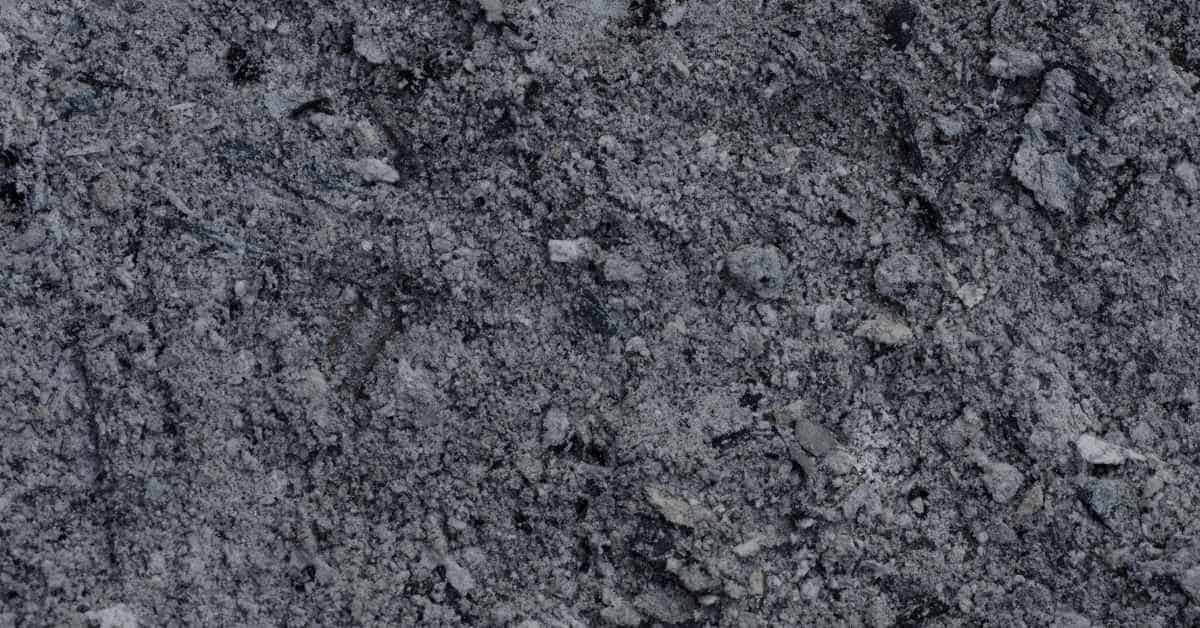 Close-up of gray, crumbly cementitious powder with small stones – alternate view 2