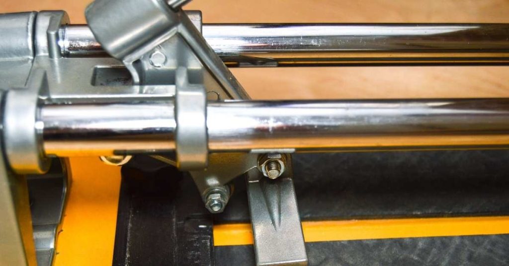 Closeup of metal rails and cutting guide on tile cutter