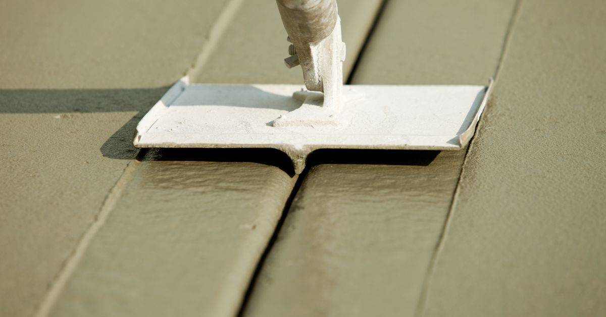 Close-up of concrete surface being smoothed with a flat tool