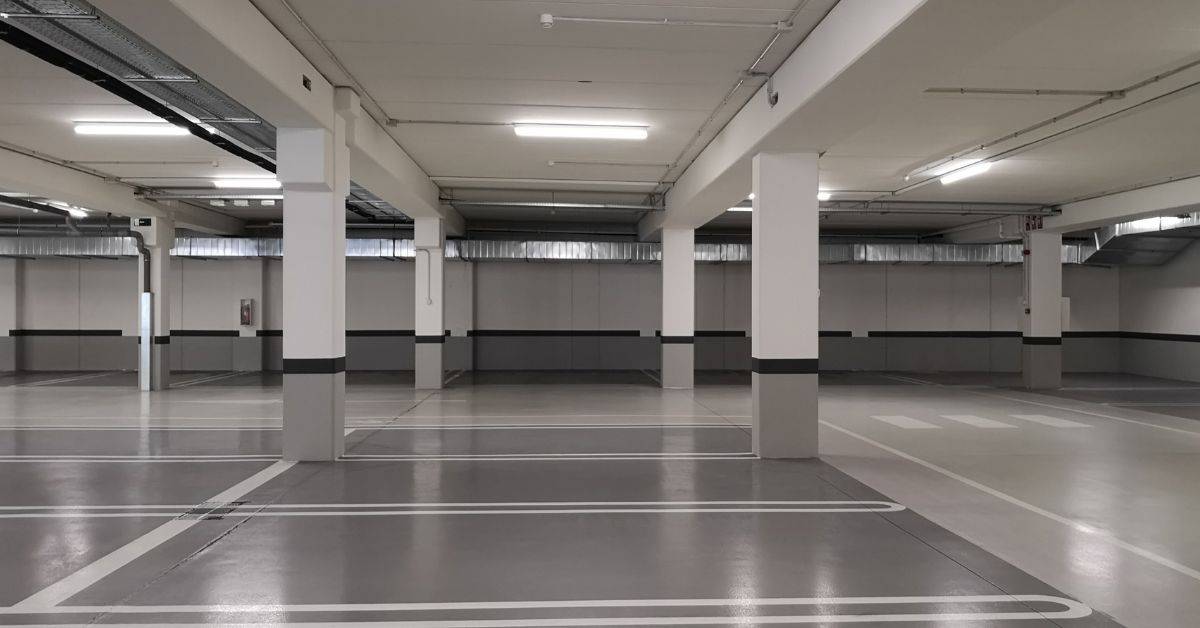 Empty indoor parking garage with concrete floors and support pillars