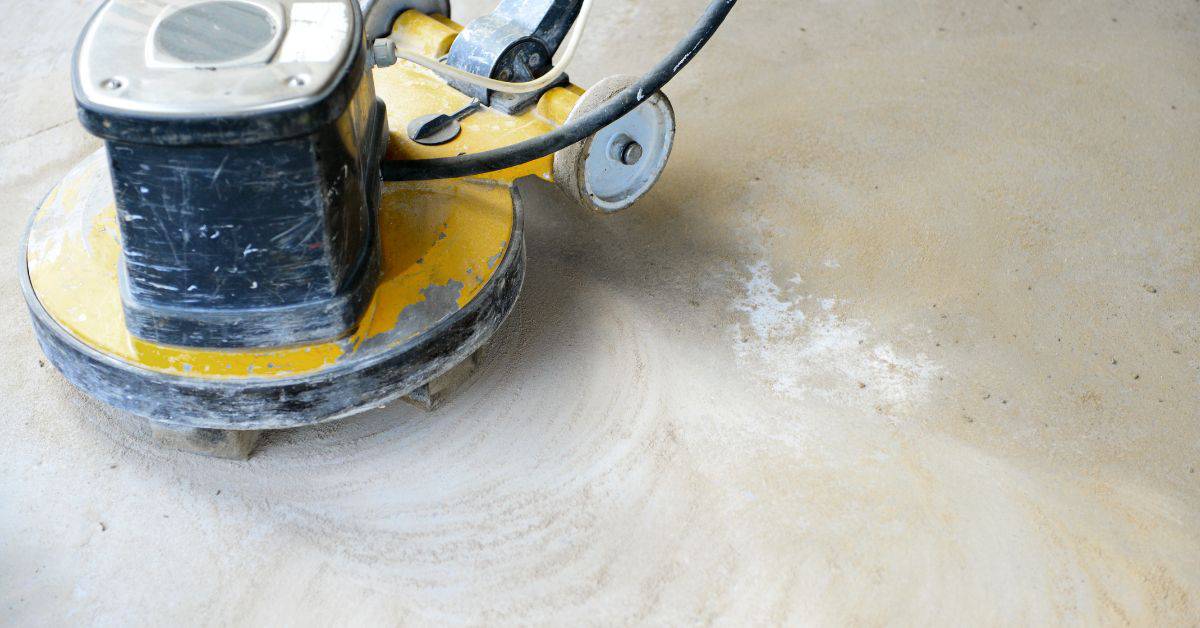 Close up of yellow concrete floor grinding machine in use