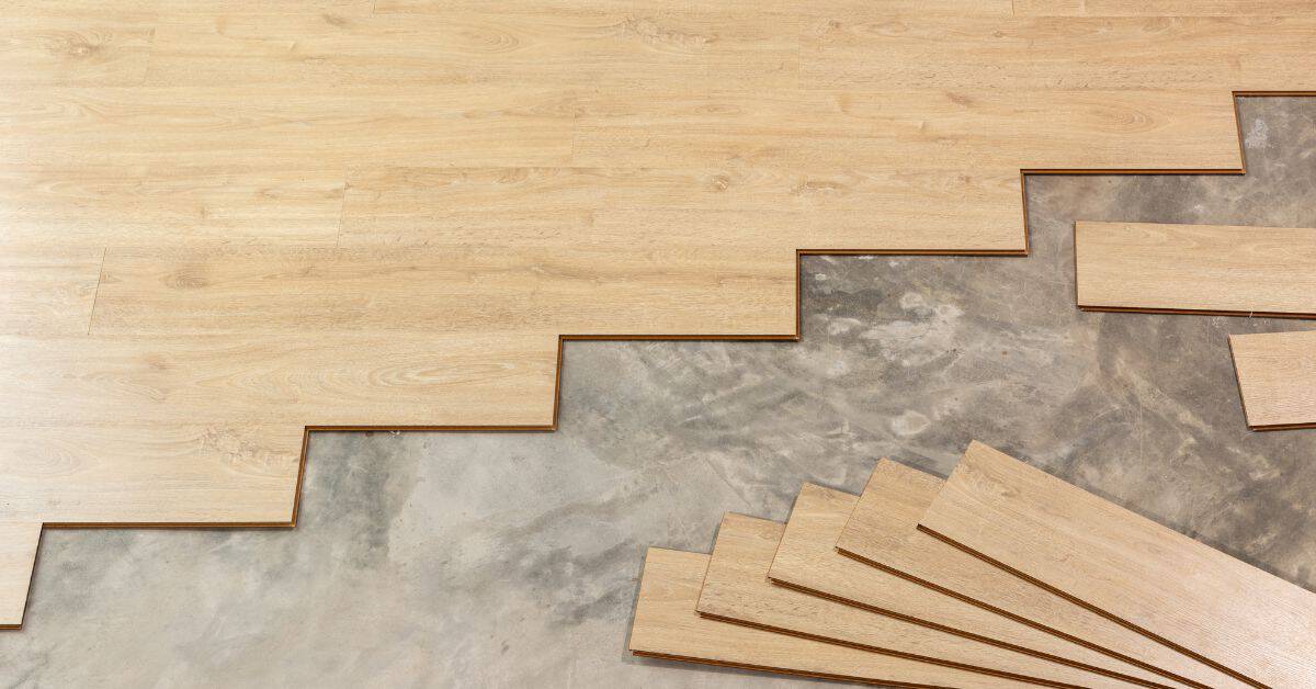 Partially installed wood-look vinyl plank flooring on concrete subfloor