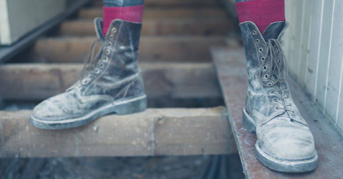 Worn boots standing on wooden floor joists