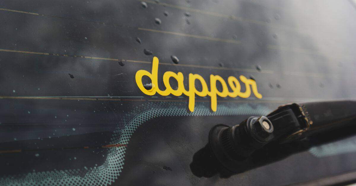 Yellow dapper sticker on wet car window with raindrops