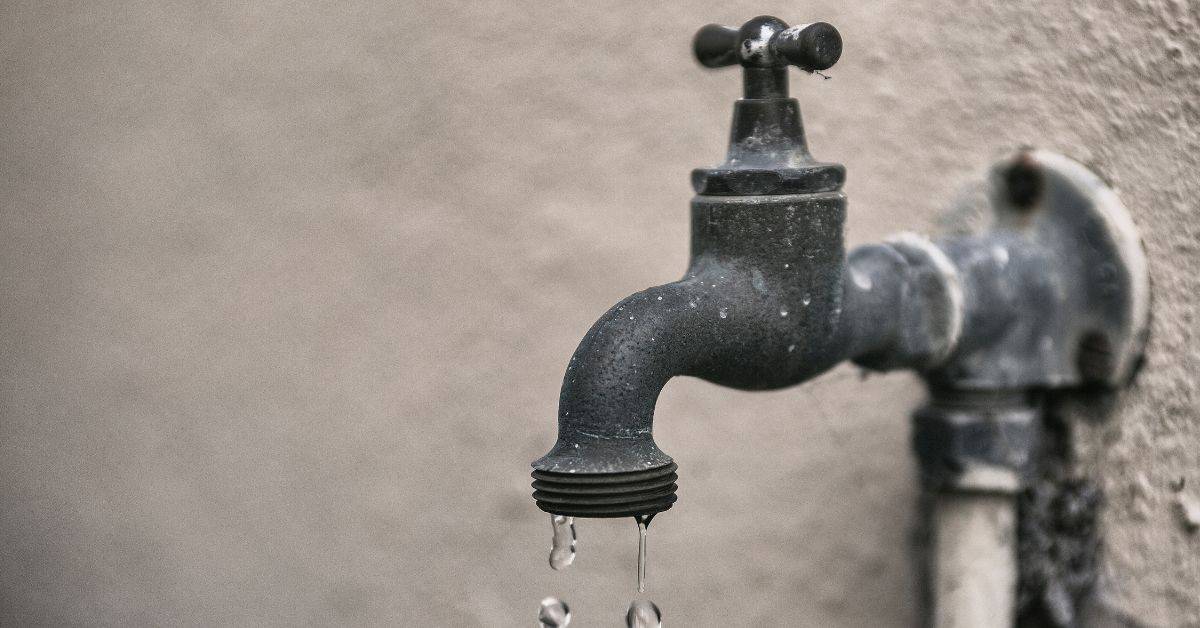 Outdoor metal water faucet dripping water drops