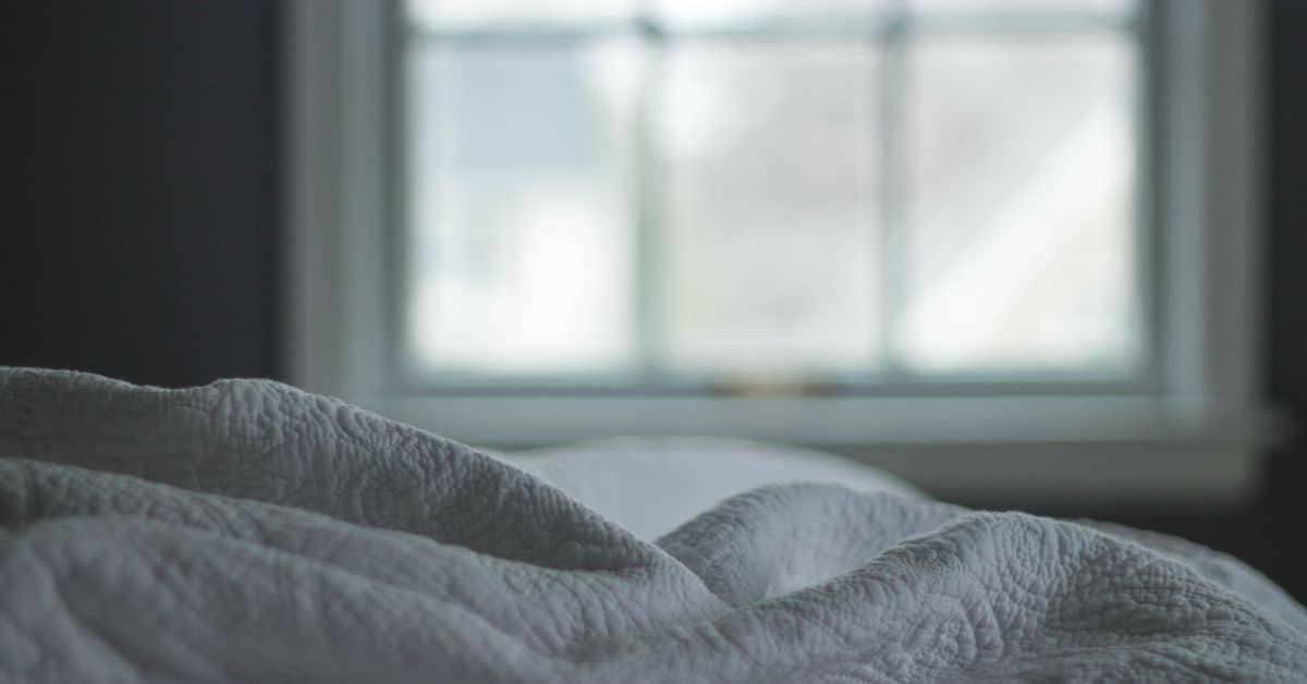 gray textured fabric folds in front of window