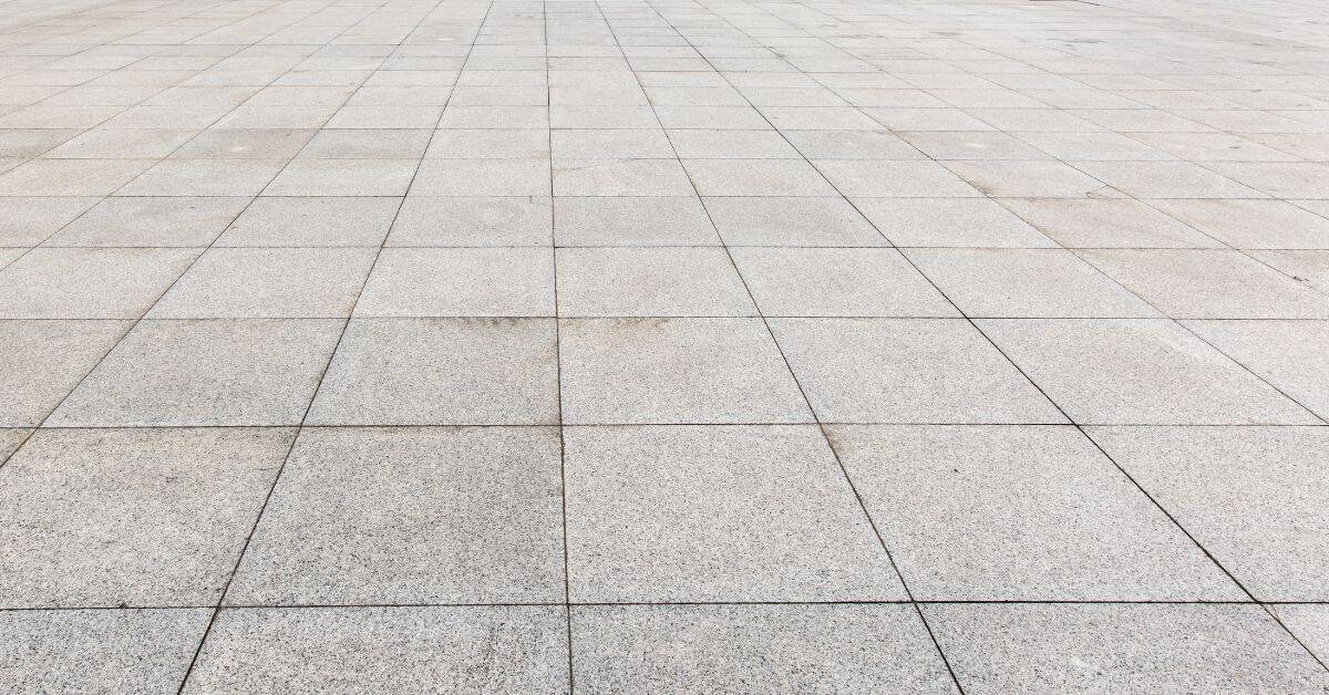 Large area of grey concrete paving slabs arranged in grid