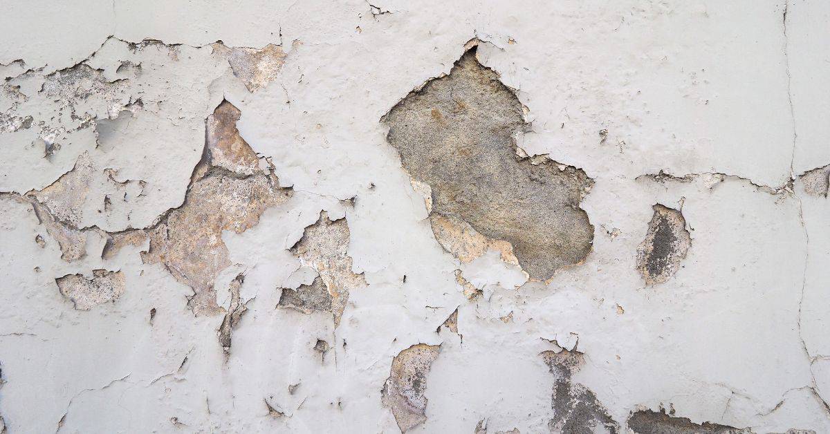 close-up of peeling paint on plaster wall surface