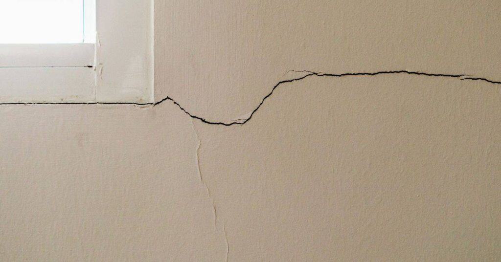 Wall with a long crack near a window frame