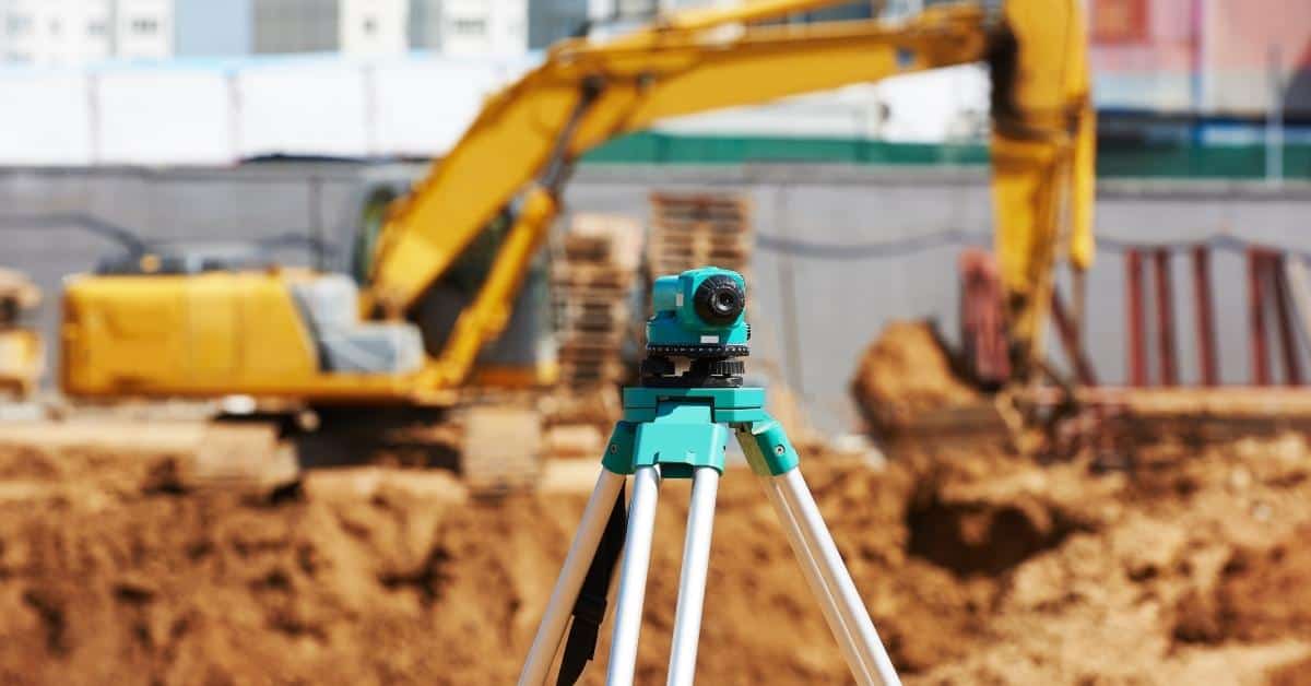 Surveying level on tripod at construction site