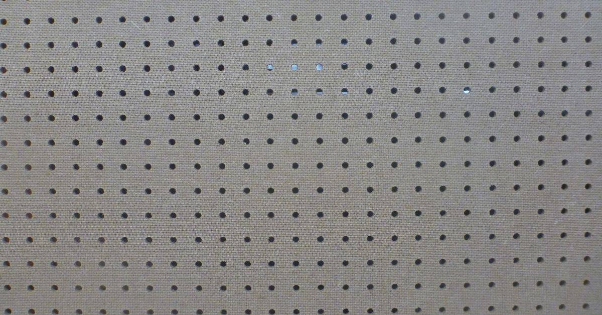 Painted pegboard with regularly spaced round holes