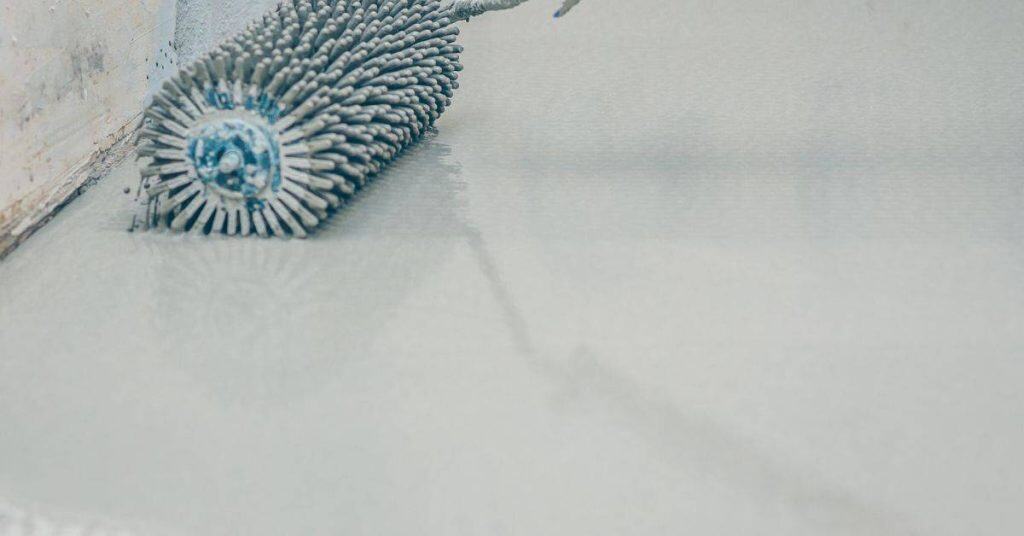 spiked roller on wet concrete floor surface