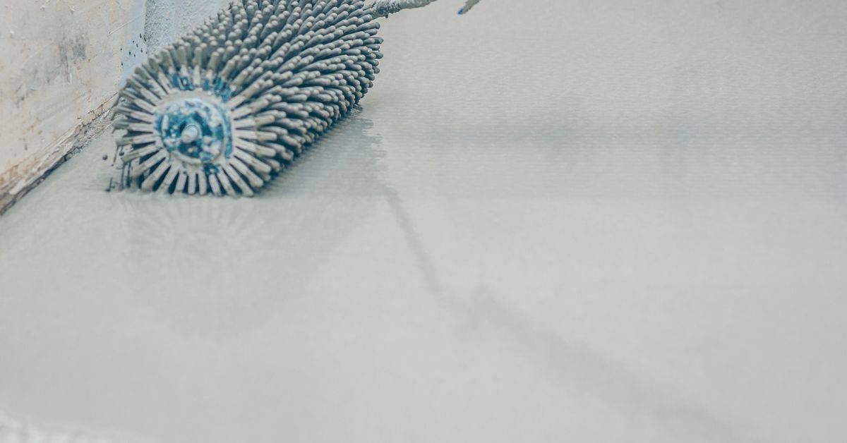 spiked roller on wet concrete floor surface