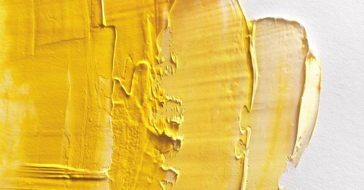 Close up of yellow paint texture on white surface