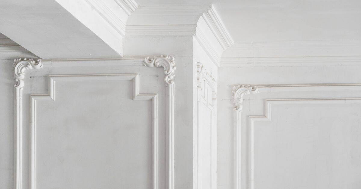 White plaster molding and decorative panels at inside corner