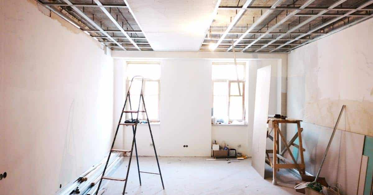 Room with exposed ceiling grid and construction tools