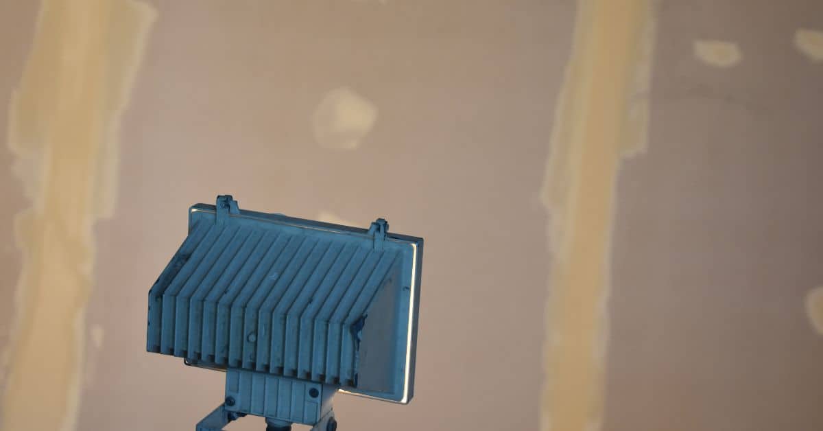 Blue construction light shining on drywall joint compound