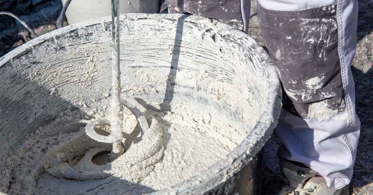 mixing plaster in bucket with electric mixer closeup