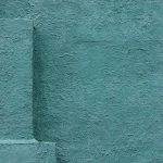 Close-up of textured blue stucco wall corner