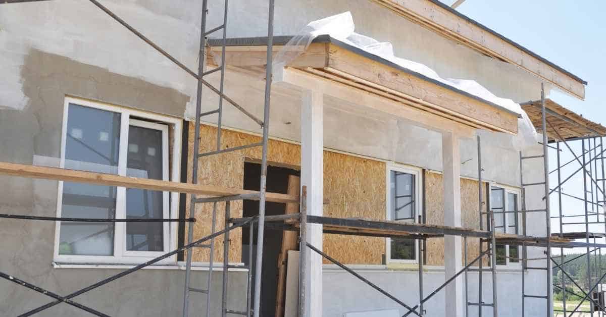 Exterior wall with scaffolding and partially applied stucco