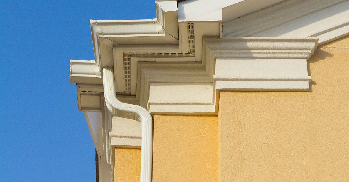 Exterior stucco wall corner with detailed trim and gutter