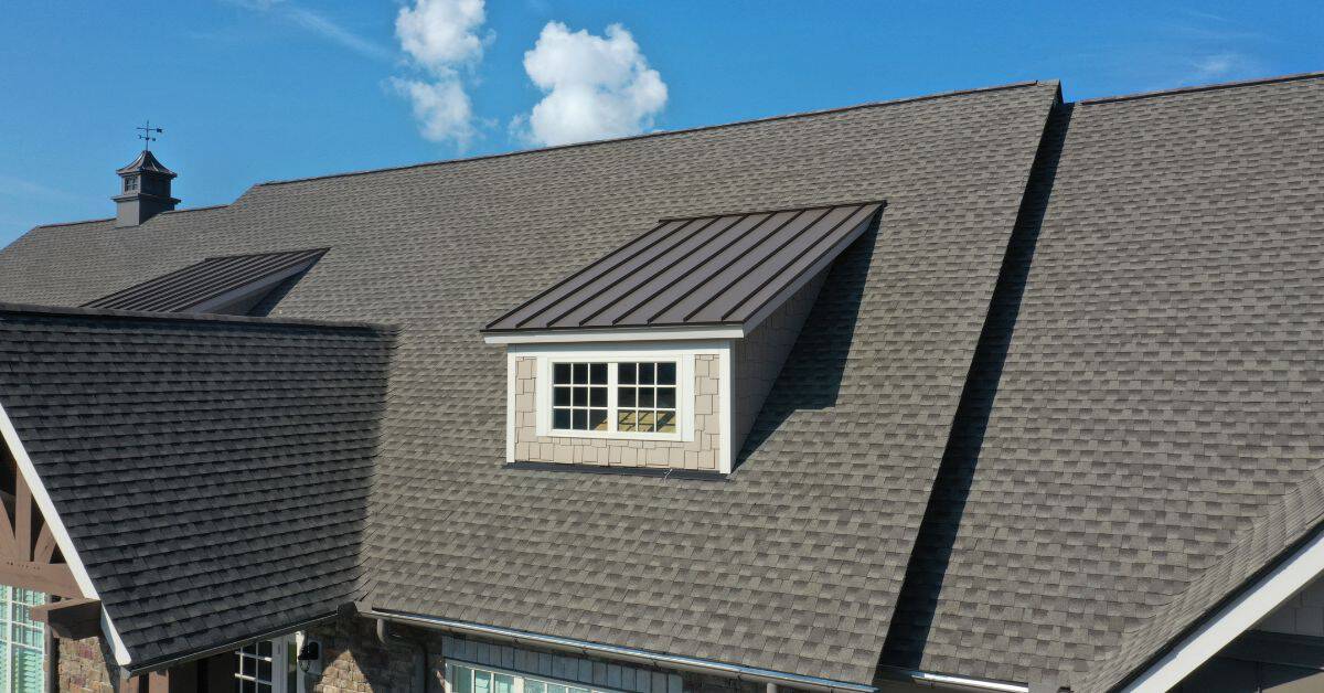 Asphalt shingle roof with dormer window under clear sky