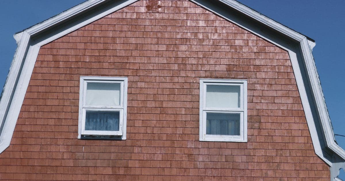 Gambrel roof with wood shingle siding and two windows