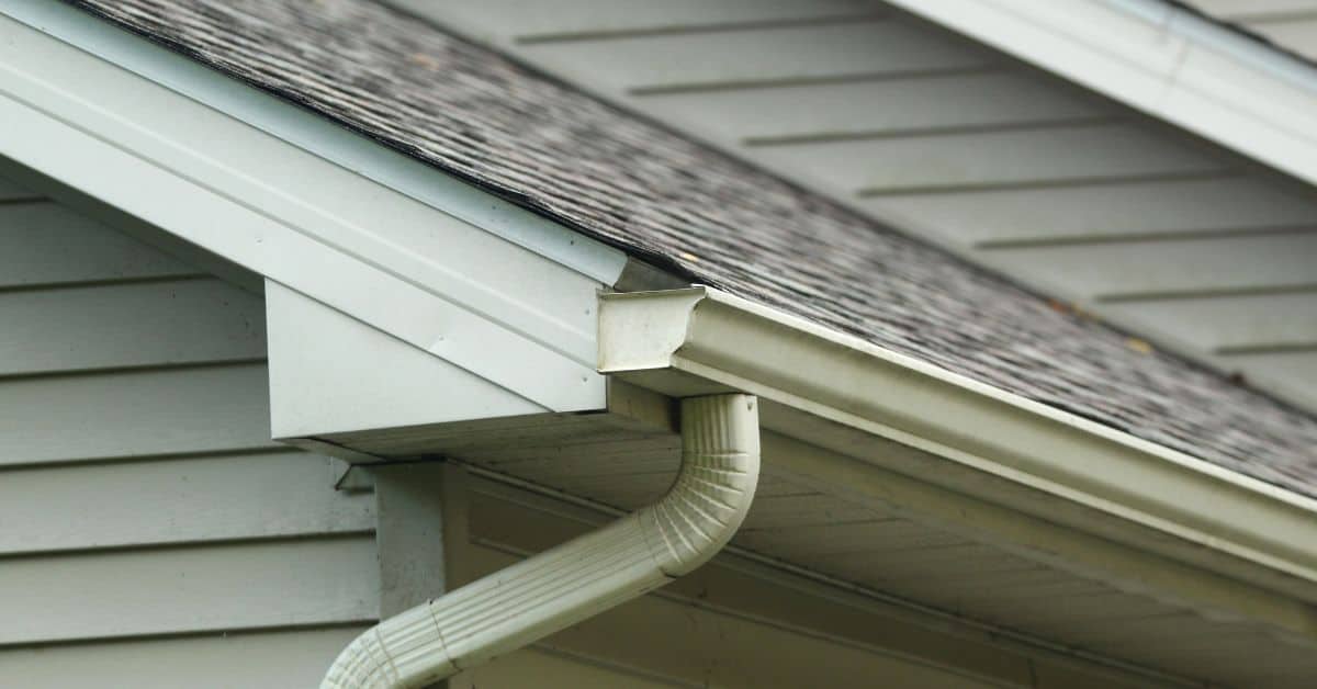 Roof eaves with gutter and downspout on house exterior