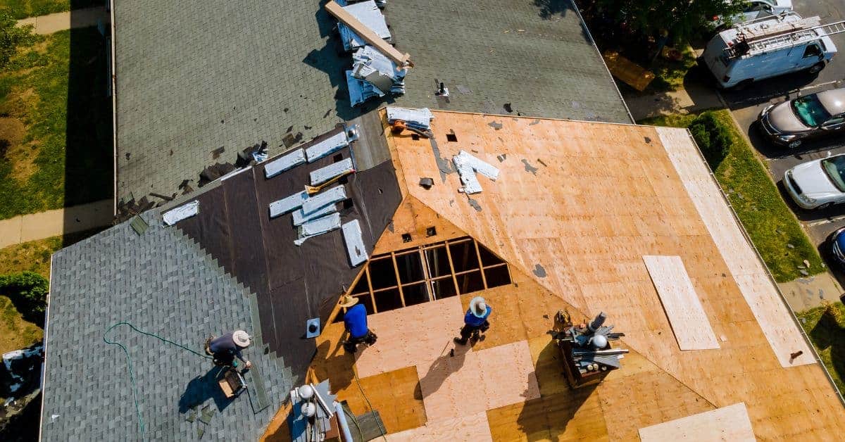 Aerial view of roof under construction with plywood and workers