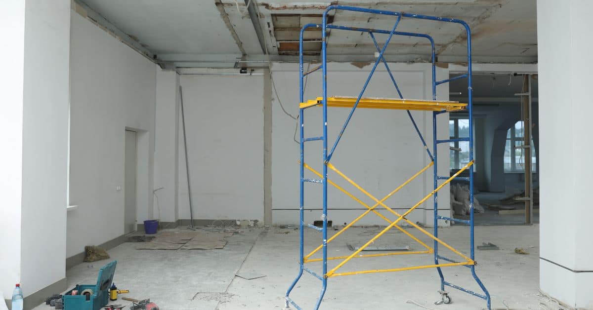 Empty indoor construction site with blue and yellow scaffolding