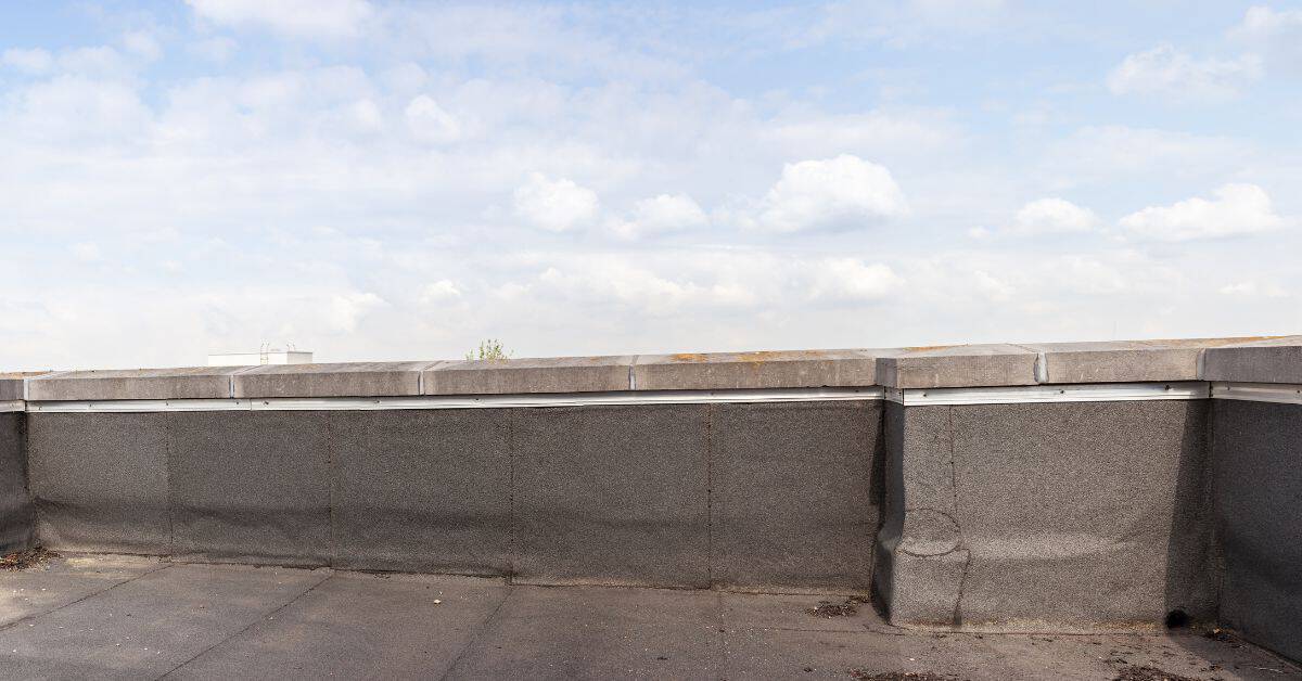 Flat roof parapet wall with metal apron flashing installed