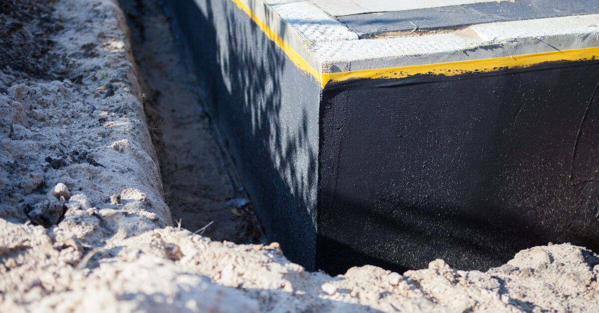 Concrete foundation wall with black waterproof coating