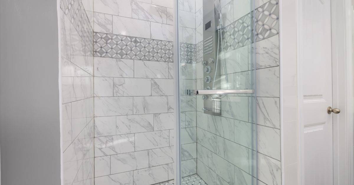 Shower with marble-look tile wall and glass door