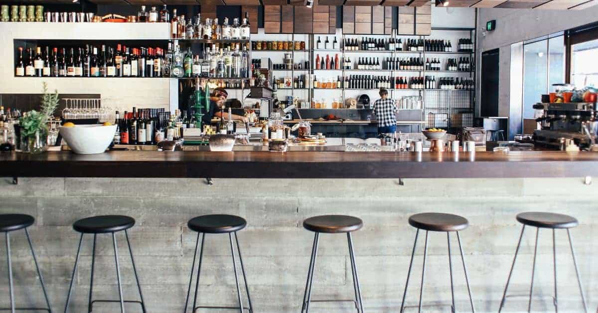 Bar counter with concrete front and metal stools