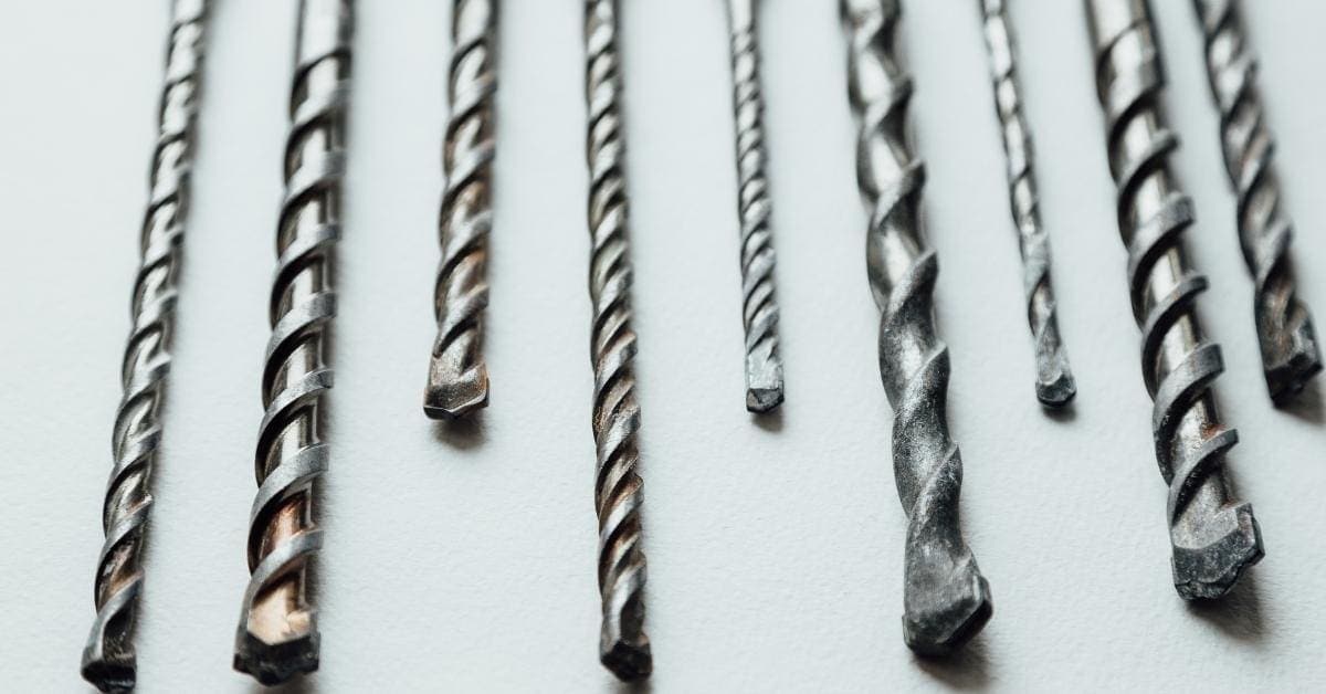 assorted metal drill bits for concrete on white surface