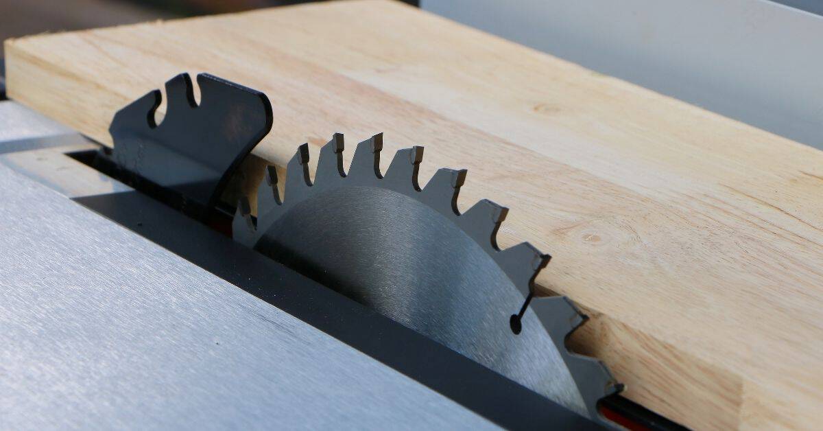 Circular saw blade set in table saw cutting wood plank