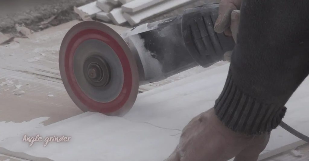 Angle grinder cutting a concrete surface with dust