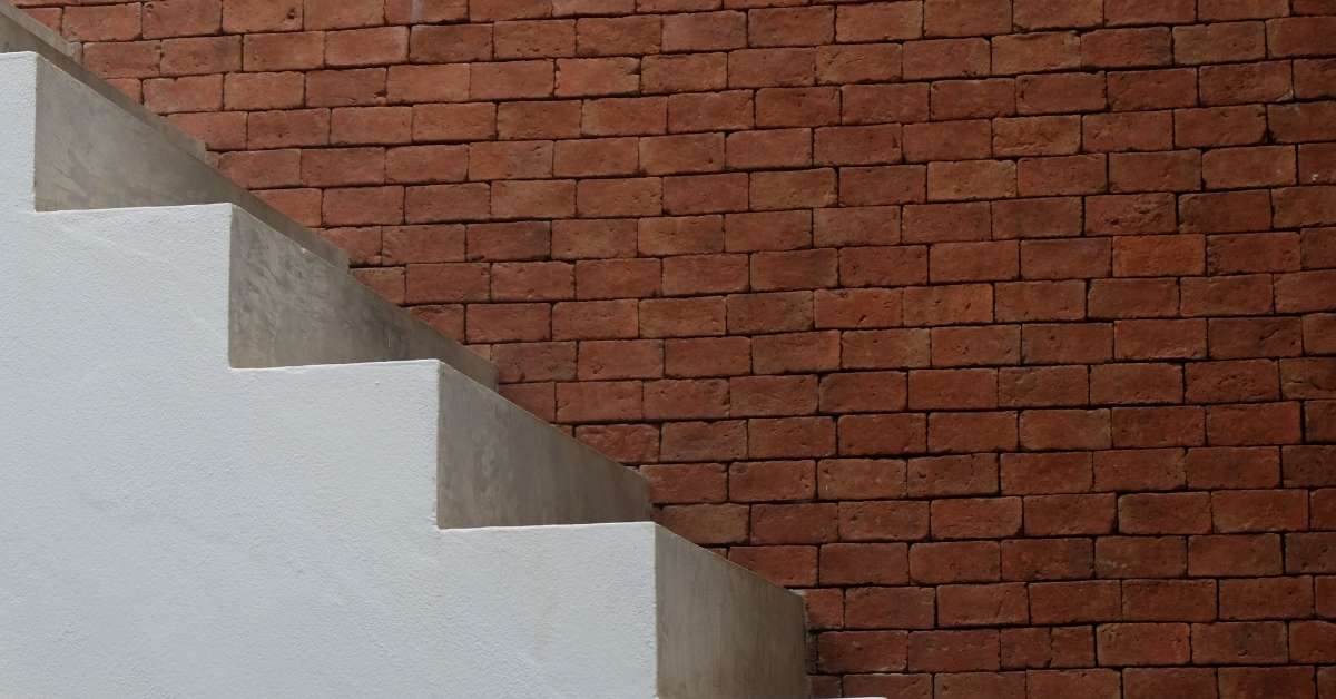 Concrete stairs adjacent to a red brick wall