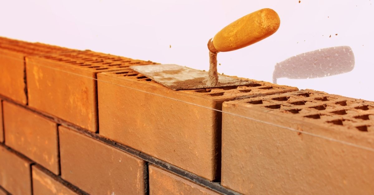 Trowel resting on hollow block bricks with string line