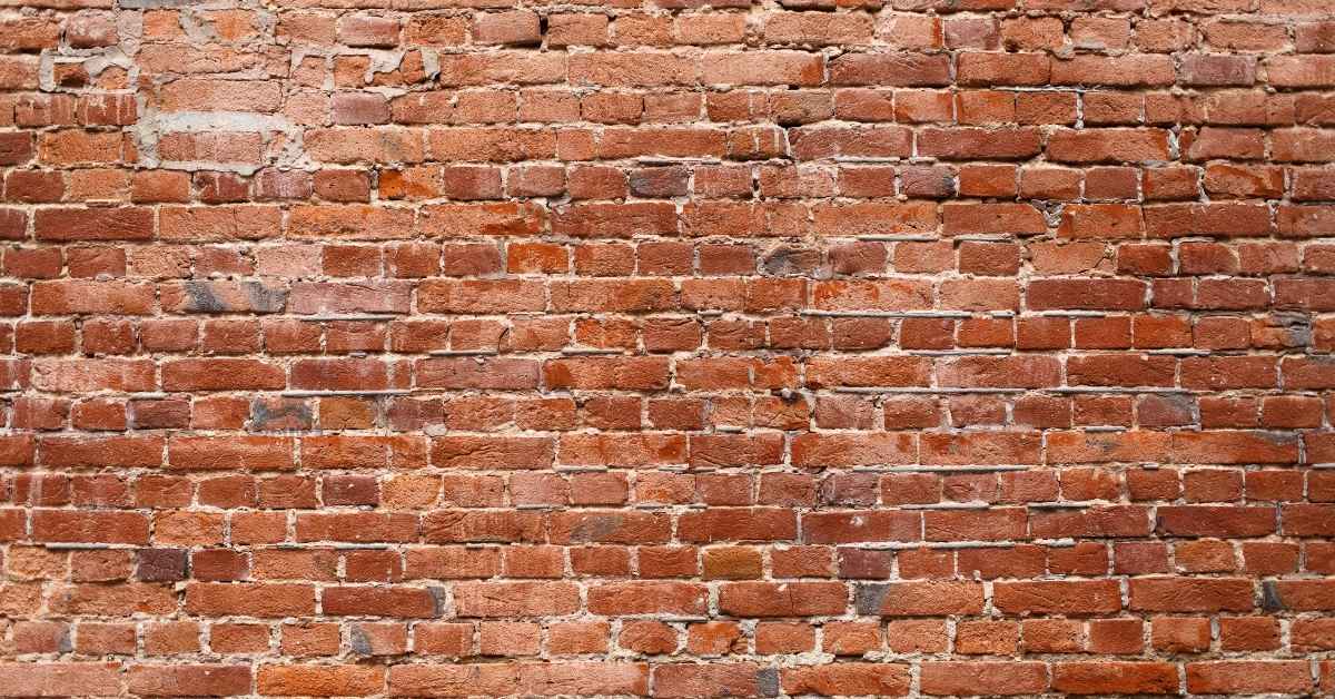 weathered red brick wall with mortar joints