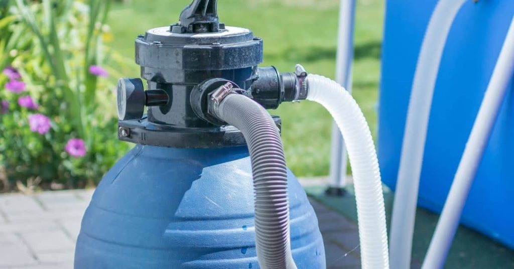 Close-up of blue pool filter tank with connected hoses