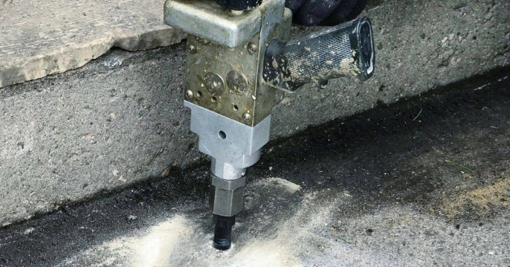 Close-up of concrete injection repair tool on cracked concrete