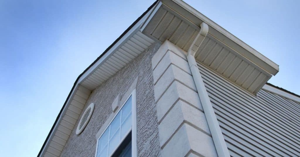 Close-up of house corner showing fascia drip edge gutter downspout