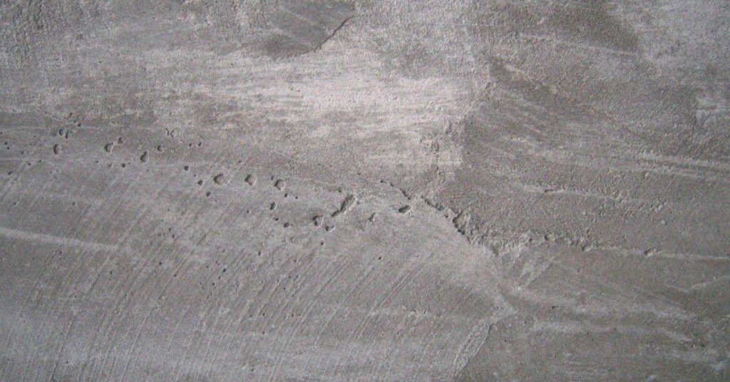 Close-up of old concrete surface with surface pitting and rough texture