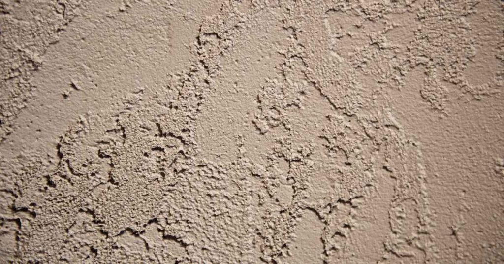 Close-up of rough stucco wall texture in neutral color